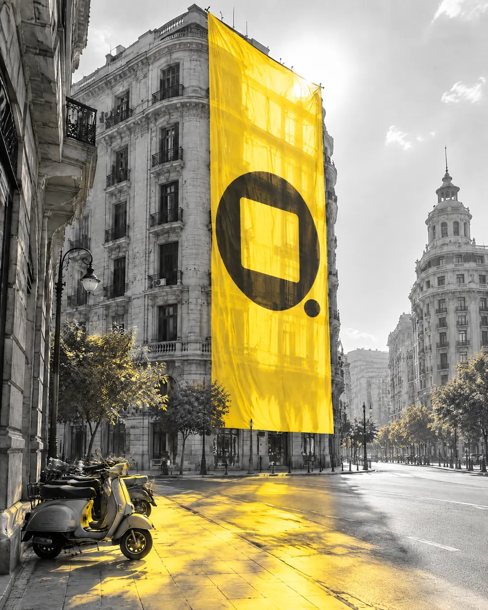 A giant yellow banner with the Qucina symbol hanging down a building in downtown Cairo, flooding the street with yellow light.